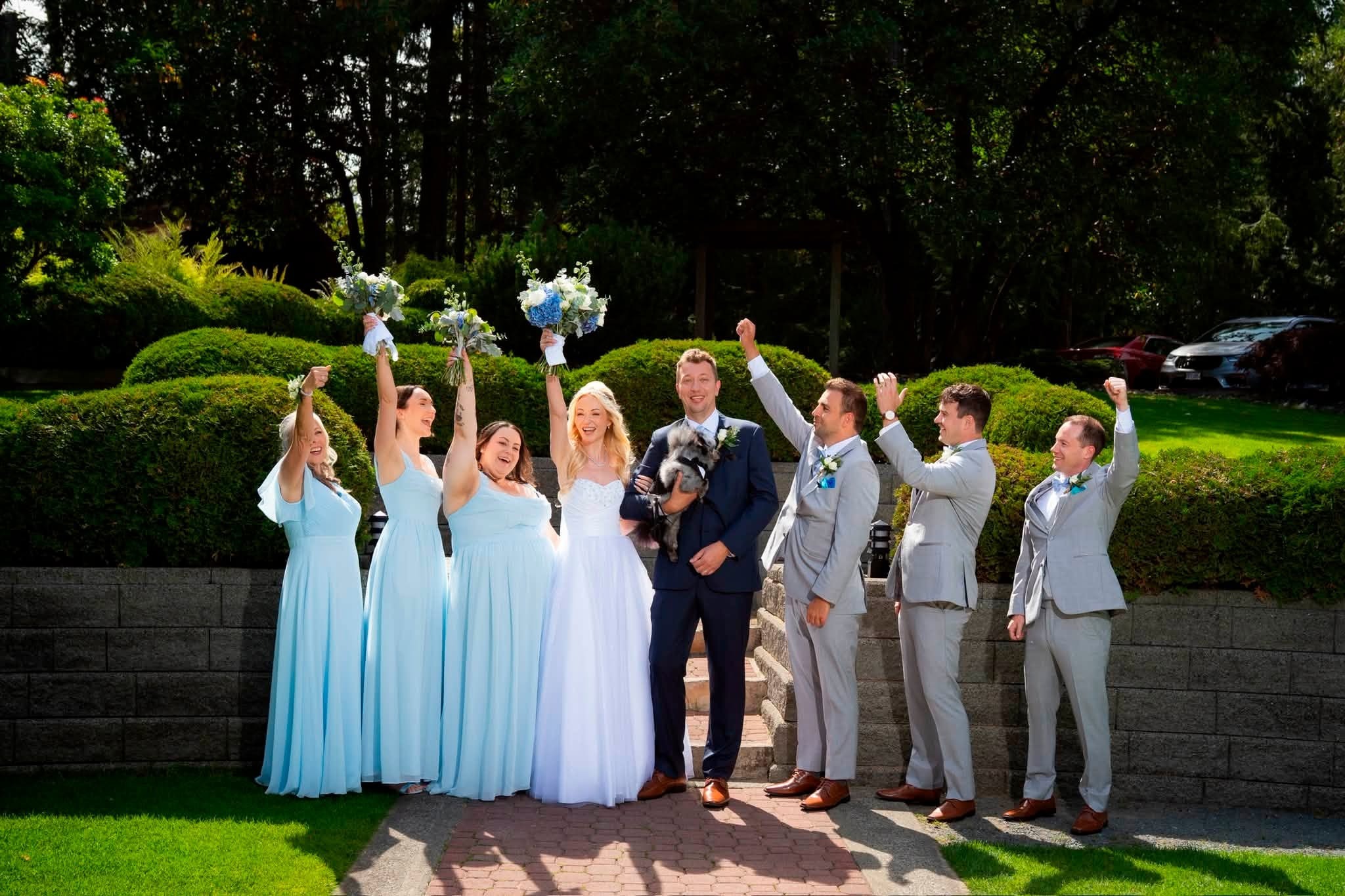 The wedding party cheering in the Tigh-Na-Mara gardens