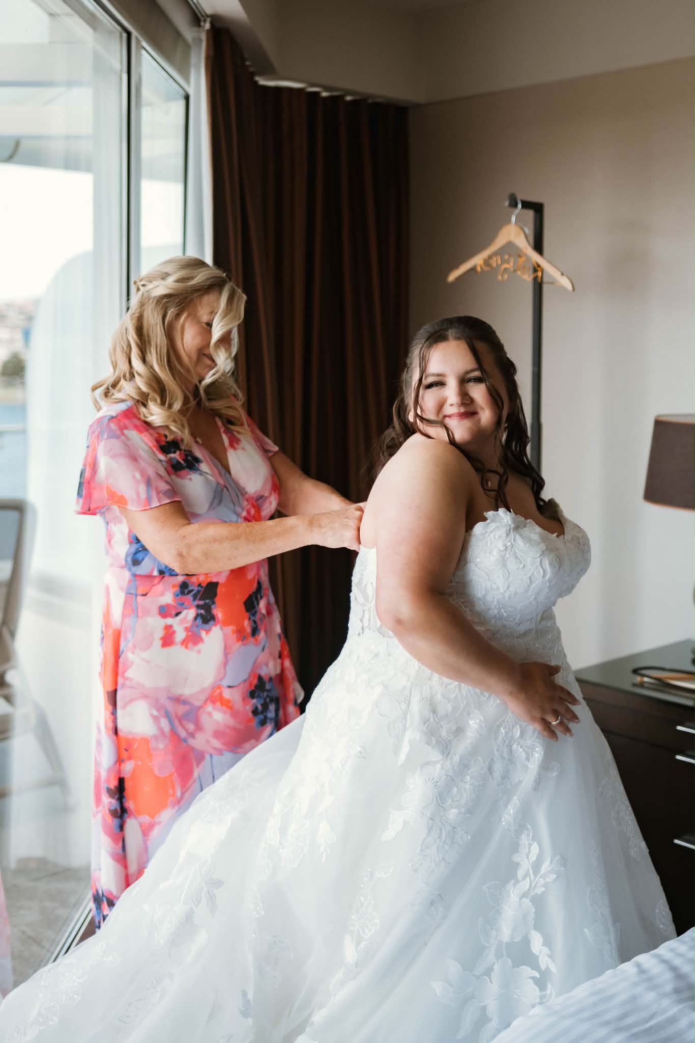 Emily's mom doing up her dress in their harbour-view suite
